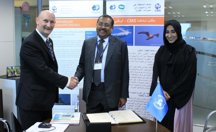 Él Excmo. Sr. T. P. Seetharam (al centro), Embajador de la India ante los Emiratos Árabes Unidos, en una ceremonia de firma celebrada en la Oficina de la CMS en Abu Dabi, con la Dra. Shaikha Al Dhaheri (a la derecha), Directora Ejecutiva, Sector de la Biodiversidad Terrestre y Marina, Organismo de Medio Ambiente - Abu Dhabi (EAD), y el Sr. Nick P. Williams (a la izquierda), Jefe de la Unidad de Coordinación del MdE sobre rapaces. Foto por cortesía de la Organismo de Medio Ambiente - Abu Dabi.
