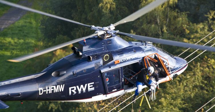 Installation of bird flight diverters by helicopter on a high voltage power line in Germany. Credit: © RWE Netzservice