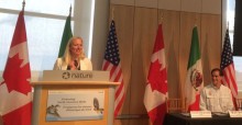 The Hon. Catherine McKenna, Environment Minister of Canada (standing at dias)